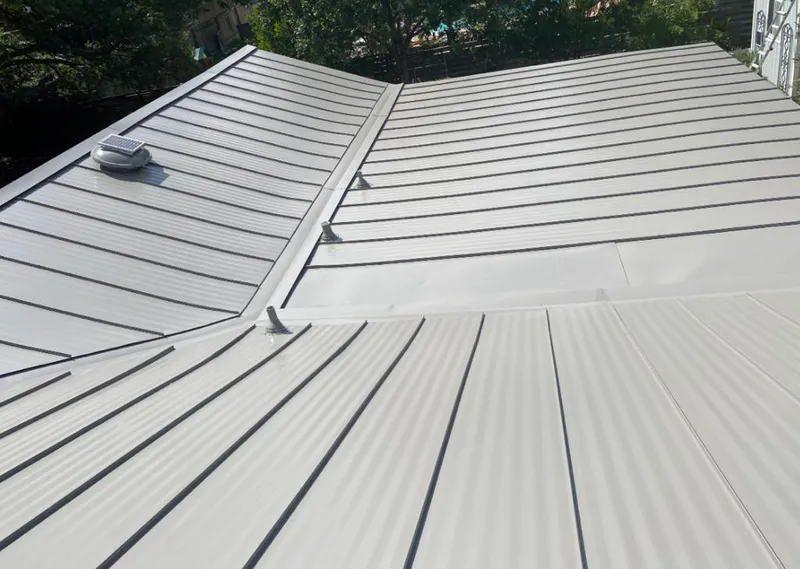 Solar attic fan installed on a metal roof for Roof Ventilation in Aldine